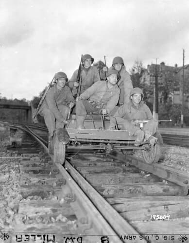 SC 195609 - Typical Yank ingenuity in making or finding transportation is exemplified in this dilapidated French gasoline handcar these GIs have rigged up to take them to and from their forward command post each day.
