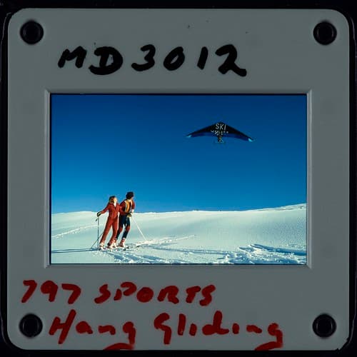 A motorised hang glider over the Cardrona ski field, Otago Photographer: W. Cleal and S. Raynes August 1982