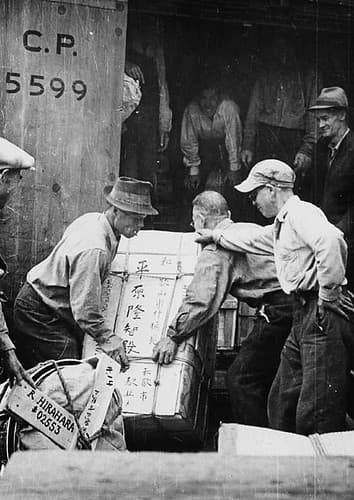 Japanese-Canadian men load a train travelling to camps in the interior of British Columbia / Canadiens d’origine japonaise chargeant un train qui se rend à des camps de la région intérieure de la Colombie-Britannique