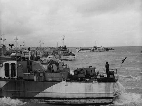 View looking west along “Nan White” beach, showing infantry landing craft on D-Day / Vue direction ouest le long du secteur « Nan White », et des barges de débarquement le Jour J