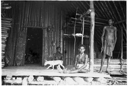 35mm negative by Oskar Speck depicting two men and a woman on a hut's verandah