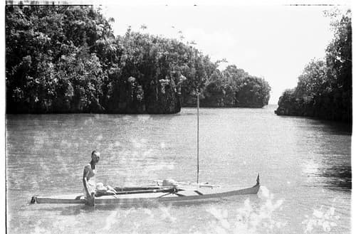 Oskar Speck standing in river beside his kayak SUNSCHIEN