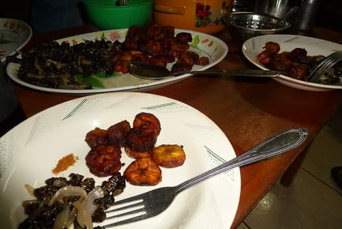Gusanos negros con cebolla y plátano macho frito.